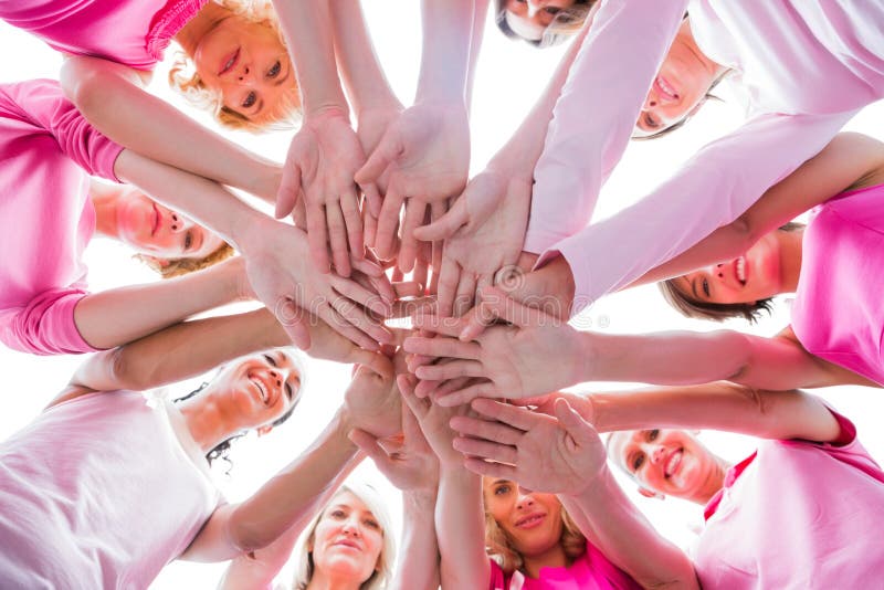 Diverse donne che sorridono nel rosa d'uso del cerchio per cancro al seno immagini stock libere da diritti Diverse donne che sorridono nel rosa d'uso del cerchio per cancro al seno immagini stock libere da diritti