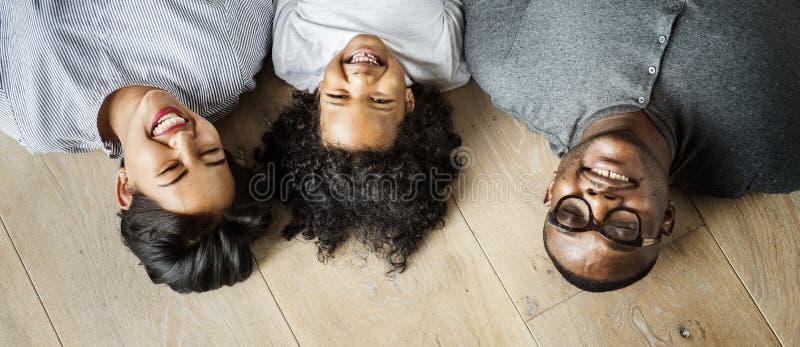 Diverse family lying on wooden floor design space