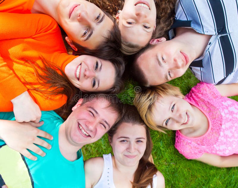 Diverse groep vrienden buiten het liggen op een gazon stock foto Diverse groep vrienden buiten het liggen op een gazon stock foto