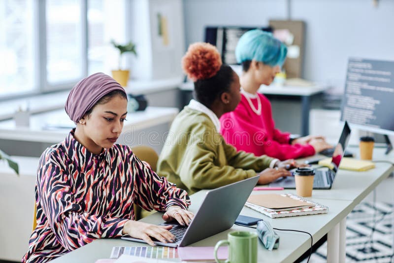 Diverse group of creative Muslim woman using laptop royalty free stock image