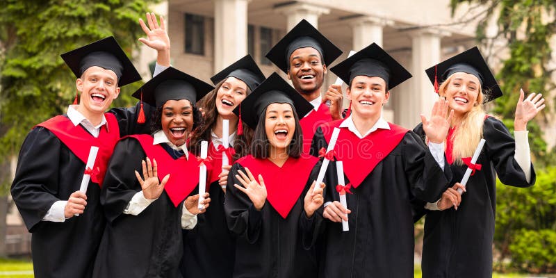 Diverse internationella studenter med examensbevis som firar gradering inom stängda dörrar arkivfoton