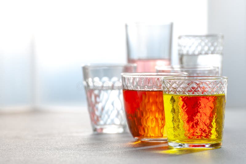 Diverse limonades in glas gefacetteerde glazen op een grijze lijst royalty-vrije stock fotografie Diverse limonades in glas gefacetteerde glazen op een grijze lijst royalty-vrije stock fotografie