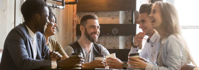 Diverse millennial cheerful friends spending free time together at cafe royalty free stock image