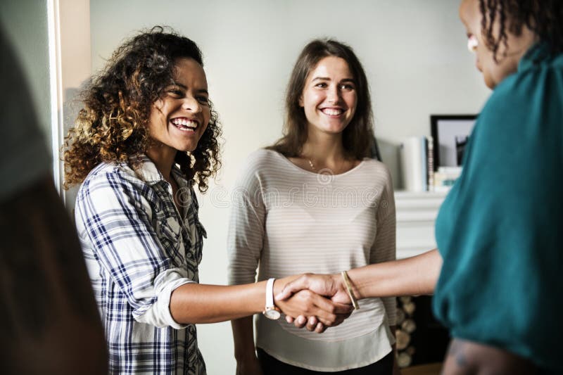 Diverse women shaking hands smiling