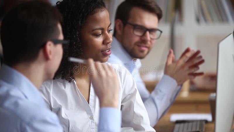 Diversi colleghi che lavorano insieme discutendo progetto informatico online nel luogo di lavoro