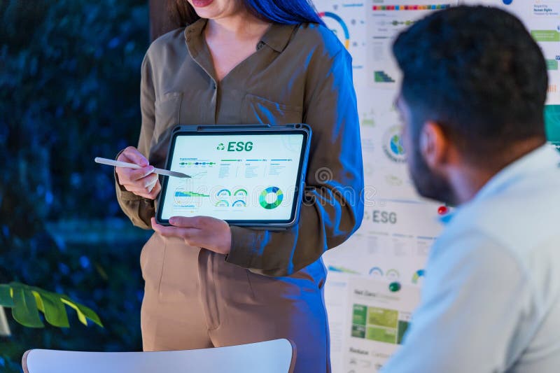 Diversity team presentation about ESG sustainability business goals sdgs in green office at night royalty free stock photography
