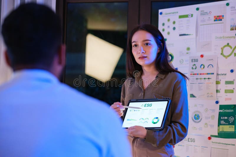 Diversity team presentation about ESG sustainability business goals sdgs in green office at night stock photo
