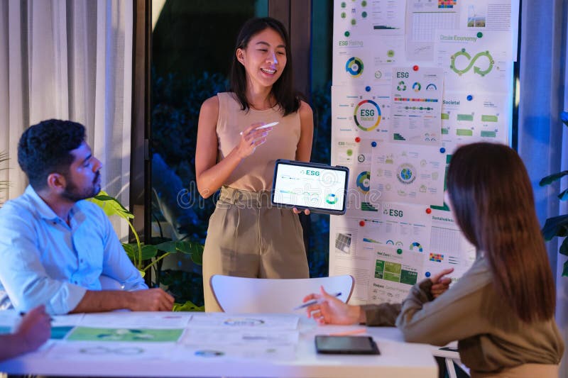 Diversity team presentation about ESG sustainability business goals sdgs in green office at night stock images
