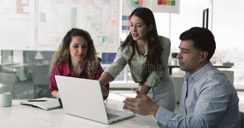 Diverso equipo de tres jóvenes felices colegas discutiendo productos en línea almacen de metraje de vídeo