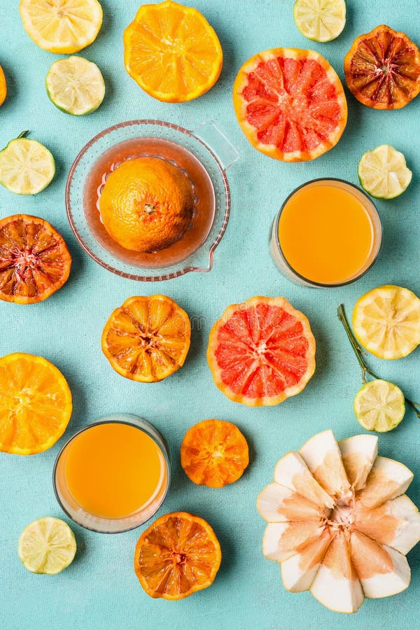 Diversos agrios tropicales coloridos con el jugo en vidrios y exprimidor de la fruta c?trica en el fondo azul claro, visi?n super foto de archivo libre de regalías Diversos agrios tropicales coloridos con el jugo en vidrios y exprimidor de la fruta c?trica en el fondo azul claro, visi?n super foto de archivo libre de regalías