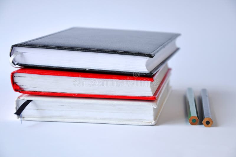 Diversos livros ou cadernos em uma tabela em um fundo branco fotografia de stock royalty free Diversos livros ou cadernos em uma tabela em um fundo branco fotografia de stock royalty free