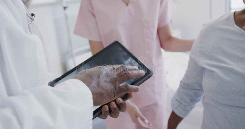 Diversos médicos masculinos con comprimido y fisiología femenina que tratan a pacientes de edad avanzada a cámara lenta metrajes