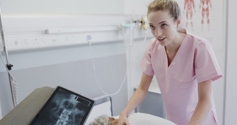 Diversos médicos masculinos con tablet y fisiología femenina que tratan a pacientes de edad avanzada a cámara lenta metrajes