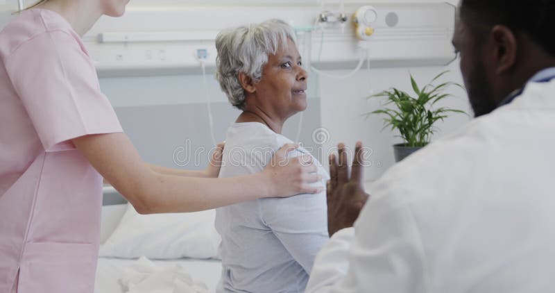 Diversos médicos y fisioterapeutas femeninos que tratan a pacientes de edad avanzada sonrientes a cámara lenta almacen de video