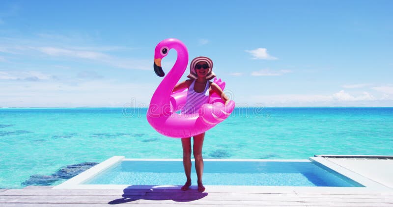 Diversão de viagem de férias. mulher engraçada dançando feliz e alegre e engraçada com a piscina flamingo flutuando em torno da ci