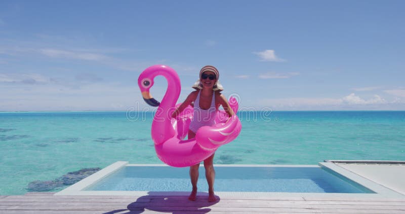 Divertida mulher divertida pulando com a piscina flamingo flutuando excitada