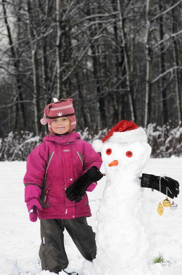 5-years old girl fun with Snowmen in Santa Hat. Copy space for your text. 5-years old girl fun with Snowmen in Santa Hat. Copy space for your text.