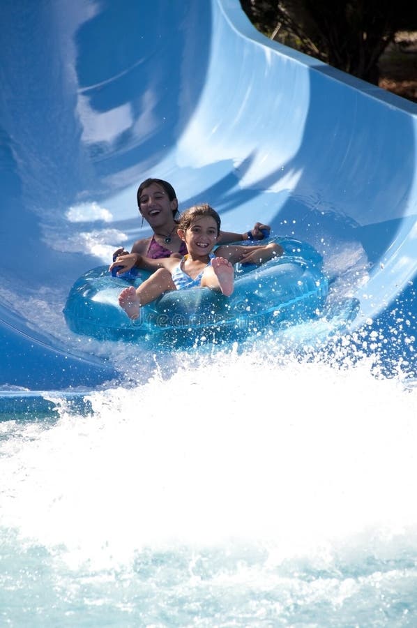 Two sisters enjoying a water slide ride. Two sisters enjoying a water slide ride.