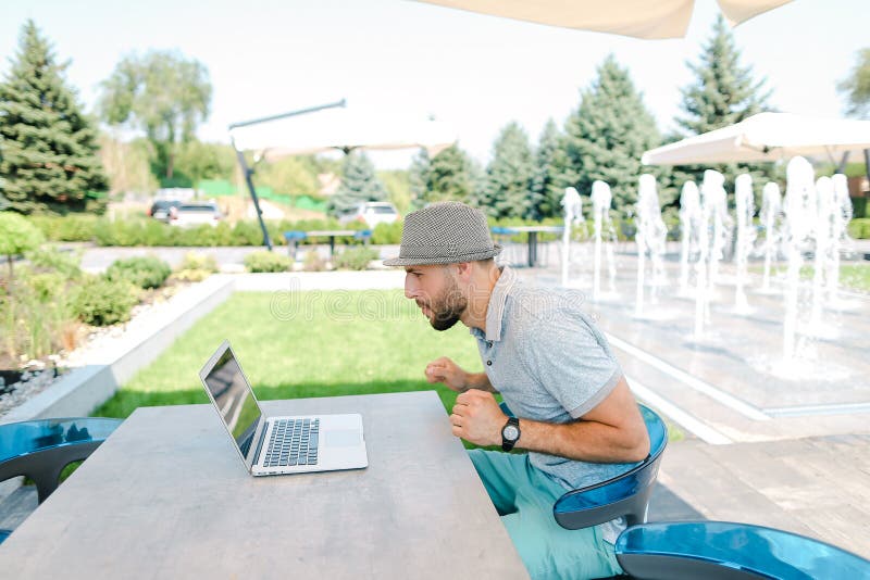 Divertimento su una sedia a sacco e supporto di una squadra sportiva preferita in streaming dal vivo con laptop. immagine stock libera da diritti