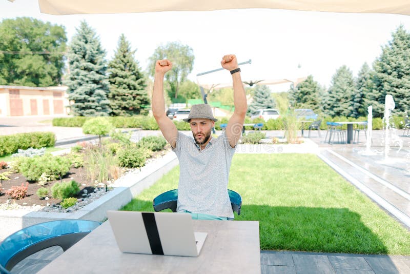 Divertimento su una sedia a sacco e supporto di una squadra sportiva preferita in streaming dal vivo con laptop. immagine stock libera da diritti