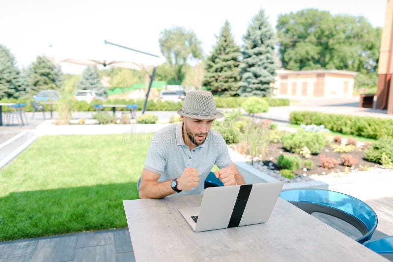 Divertimento su una sedia a sacco e supporto di una squadra sportiva preferita in streaming dal vivo con laptop. fotografie stock