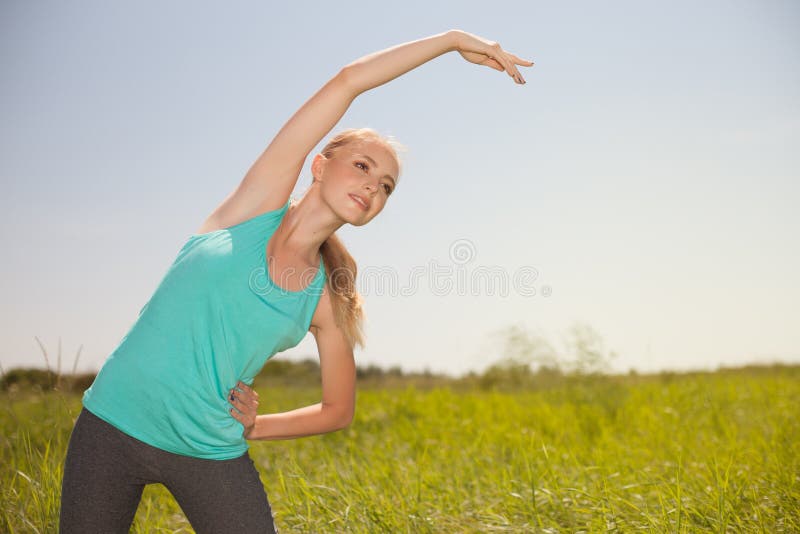 Diviértase a la mujer joven rubia de la belleza que ejercita en la yoga del aire libre imágenes de archivo libres de regalías Diviértase a la mujer joven rubia de la belleza que ejercita en la yoga del aire libre imágenes de archivo libres de regalías