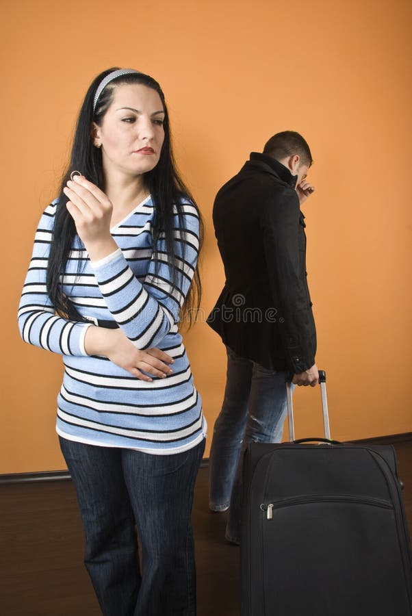 Coppia di divorzio, la donna in piedi con un anello di nozze in mano e grido di distanza e l'uomo uscire di casa con i bagagli, check anche.