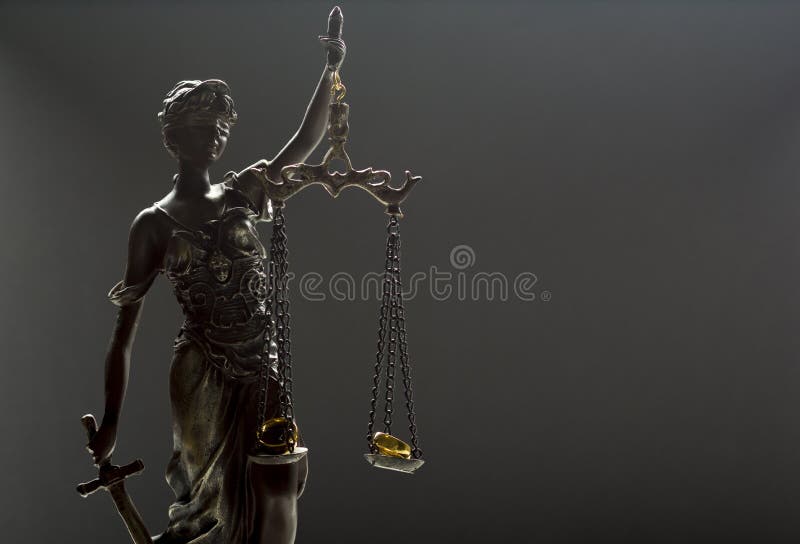 Divorce concept. wedding rings and Statue of justice themis