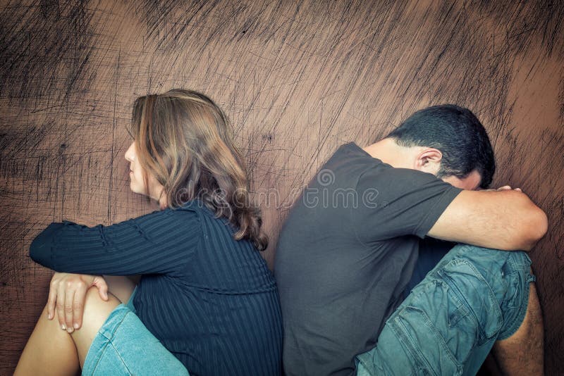 Divorce,fight,problems - Young couple angry at each other sitting back to back. Divorce,fight,problems - Young couple angry at each other sitting back to back