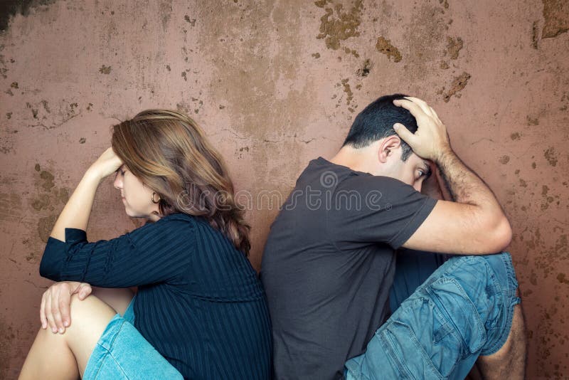 Divorce,fight,problems - Young couple angry at each other sitting back to back. Divorce,fight,problems - Young couple angry at each other sitting back to back