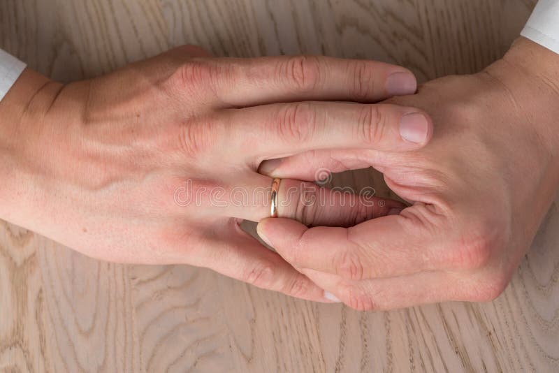 Divorce, Separation Hands of Man Removing Wedding or Engagement Ring