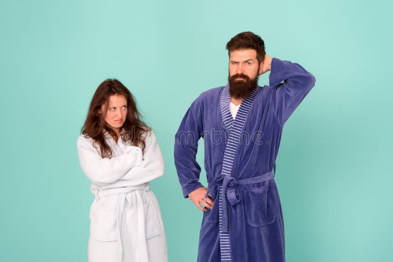 Divorce. Unhappy couple in love blue background. Sexy woman and bearded man in home clothing. Conflict between wife and