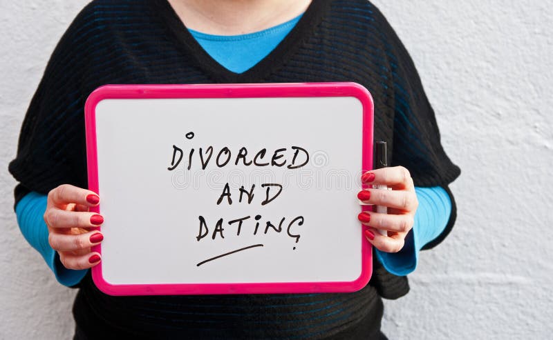 Young woman holding white chalk board with purple border and text saying ' divorced and dating ' on white background.