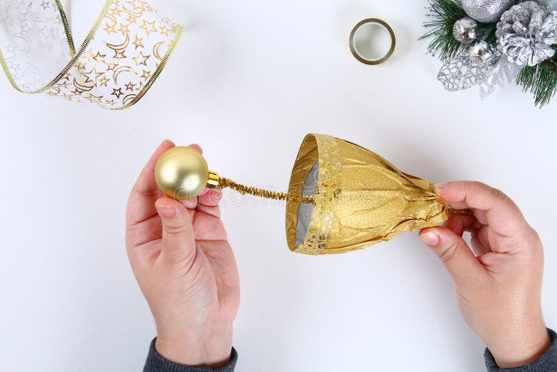 DIY gold bell from a plastic bottle. Guide on the photo how to make a decorative bell from a bottle, paper and a Christmas ball stock photo DIY gold bell from a plastic bottle. Guide on the photo how to make a decorative bell from a bottle, paper and a Christmas ball stock photo