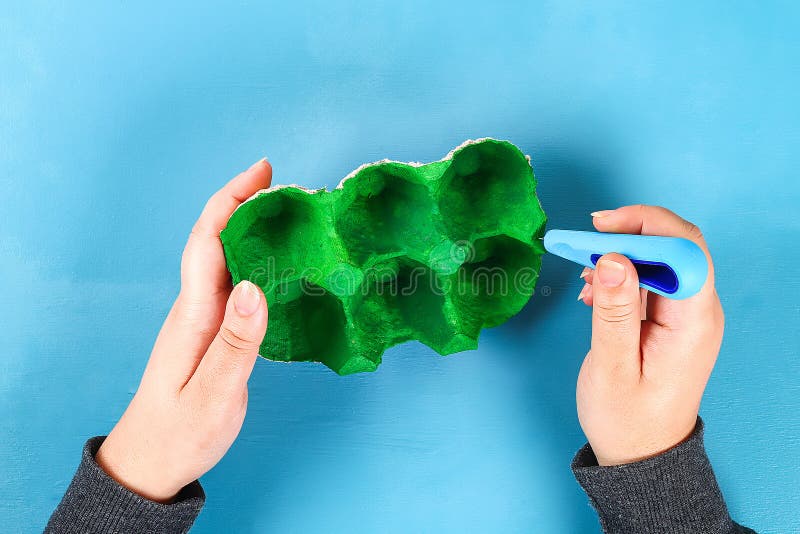 DIY-Korb Osterei vom Pappbehälter, Krepppapier, Chenillestamm auf blauem Hintergrund lizenzfreie stockfotos DIY-Korb Osterei vom Pappbehälter, Krepppapier, Chenillestamm auf blauem Hintergrund lizenzfreie stockfotos