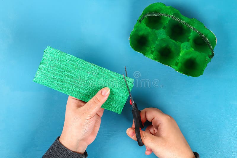 DIY-Korb Osterei vom Pappbehälter, Krepppapier, Chenillestamm auf blauem Hintergrund lizenzfreie stockfotografie DIY-Korb Osterei vom Pappbehälter, Krepppapier, Chenillestamm auf blauem Hintergrund lizenzfreie stockfotografie