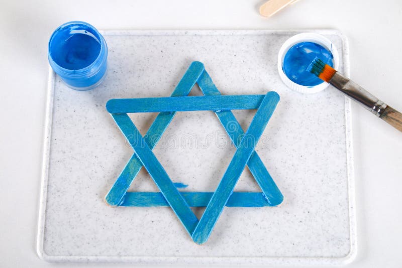 DIY Ντεκόρ Hanukkah Αστέρι του Δαυίδ από τα ραβδιά παγωτού σε έναν άσπρο ξύλινο πίνακα Οδηγός, βαθμιαία σχετικά με τη φωτογραφία στοκ εικόνα με δικαίωμα ελεύθερης χρήσης DIY Ντεκόρ Hanukkah Αστέρι του Δαυίδ από τα ραβδιά παγωτού σε έναν άσπρο ξύλινο πίνακα Οδηγός, βαθμιαία σχετικά με τη φωτογραφία στοκ εικόνα με δικαίωμα ελεύθερης χρήσης