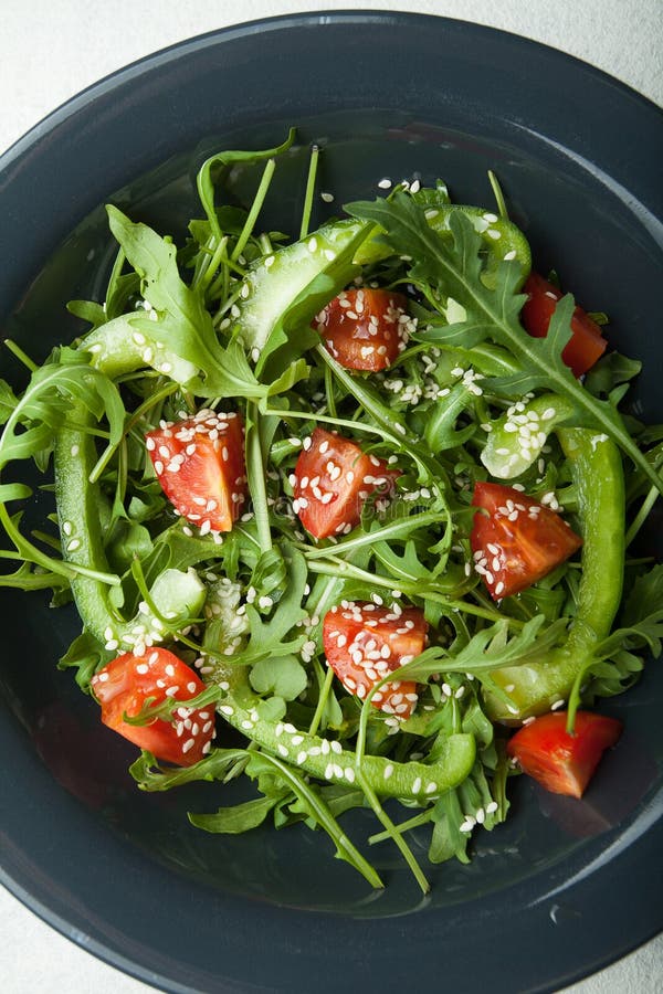 Diätetischer Salat in einer Platte von Arugula, von Paprika und von Tomaten Gesundes Essen lizenzfreie stockfotos Diätetischer Salat in einer Platte von Arugula, von Paprika und von Tomaten Gesundes Essen lizenzfreie stockfotos
