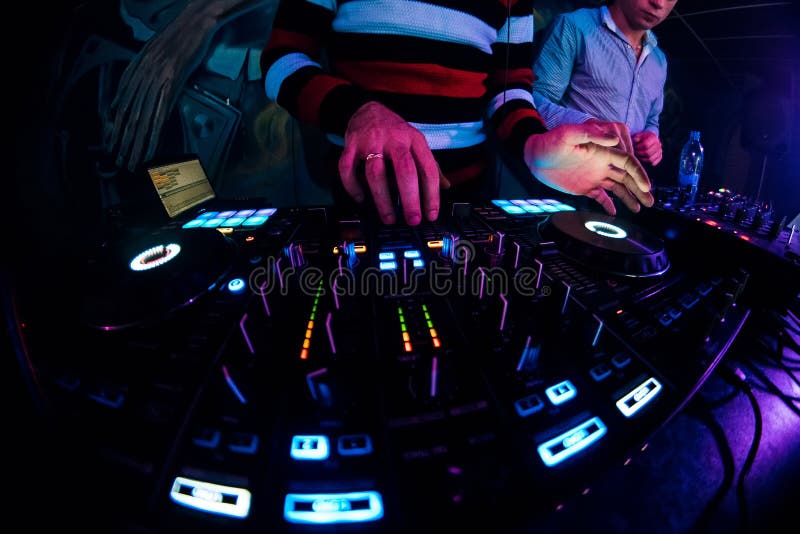 DJ in a booth playing a mixer at a nightclub stock photo DJ in a booth playing a mixer at a nightclub stock photo