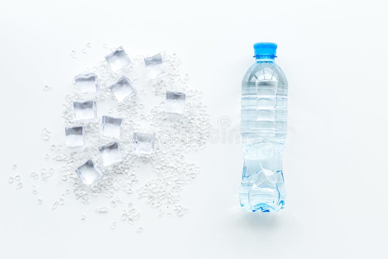 Djupfryst vatten i iskuber och plast- flaska på den vita modellen för bästa sikt för stångtabell royaltyfri fotografi Djupfryst vatten i iskuber och plast- flaska på den vita modellen för bästa sikt för stångtabell royaltyfri fotografi
