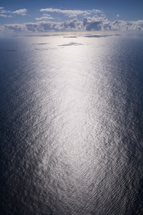 Vast aerial of the ocean emphasising the extreme glare at sea with clouds in the background. Vast aerial of the ocean emphasising the extreme glare at sea with clouds in the background