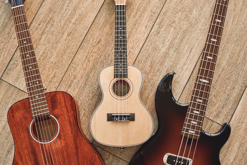 Dlaczego Wybierać Twój Pierwszy gitary Odgórnego widok na trzy różnych typach gitary: akustyczny, elektryczny i ukulele, fotografia royalty free Dlaczego Wybierać Twój Pierwszy gitary Odgórnego widok na trzy różnych typach gitary: akustyczny, elektryczny i ukulele, fotografia royalty free