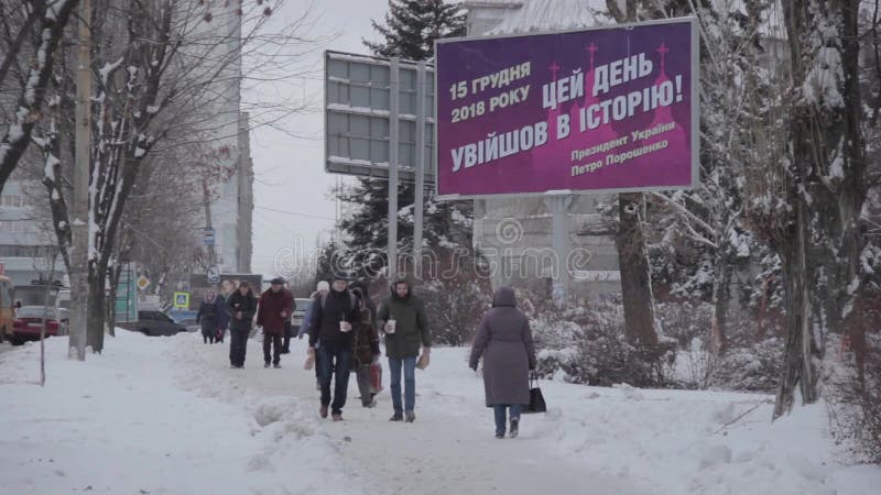 Dnipro, Ucrania - 27 de diciembre de 2018: La gente camina cerca de la cartelera Autocephaly de la iglesia ortodoxa de Ucrania To