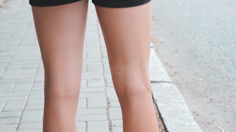 DNIPRO, UCRANIA - 3 de julio de 2019: Sandalias de goma en las piernas de una joven Mujer en pantalones cortos y mochila de pie a