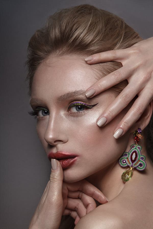 Do retrato delicado da mulher do encanto da beleza o cabelo longo louro recolheu com estilo do nude dos brincos no fundo cinzento fotos de stock Do retrato delicado da mulher do encanto da beleza o cabelo longo louro recolheu com estilo do nude dos brincos no fundo cinzento fotos de stock