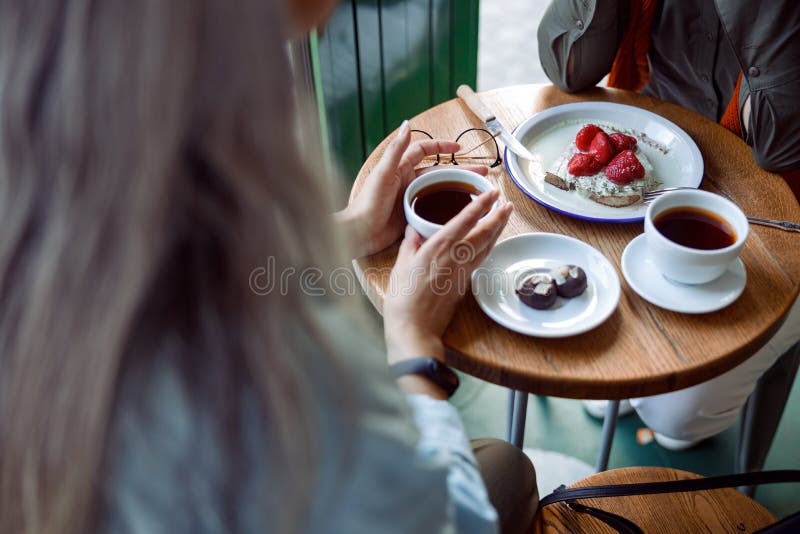 Doamna cu părul alb ia o ceașcă de cafea petrece timp cu un prieten în cafenea confortabil stock photos