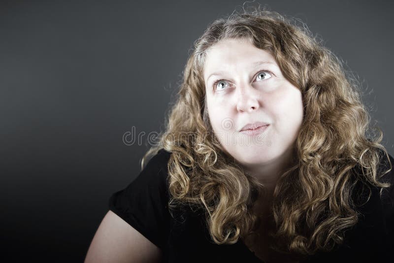 Doamnă cu părul ondulat care se uită în sus de pe cameră stock photo