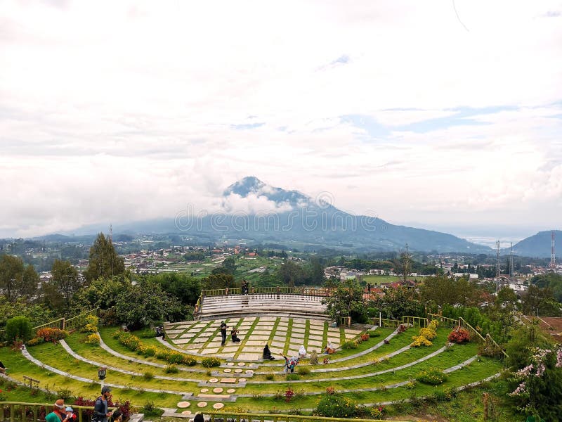 Doar fă fotografii și relaxează-te la grădinile terasate cu tipare circulare care trec cu vederea o priveliște scenică a muntelui stock photos