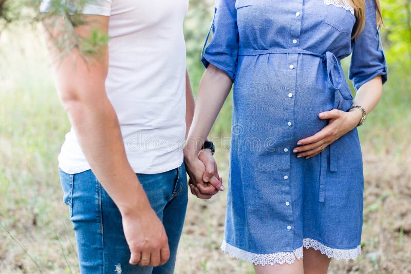 Dobiera się w miłości ciężarny cuddling, czekać na dziecka odprowadzenie w parku w ciepłym słonecznym dniu Brzemienność niebieski zdjęcia royalty free Dobiera się w miłości ciężarny cuddling, czekać na dziecka odprowadzenie w parku w ciepłym słonecznym dniu Brzemienność niebieski zdjęcia royalty free
