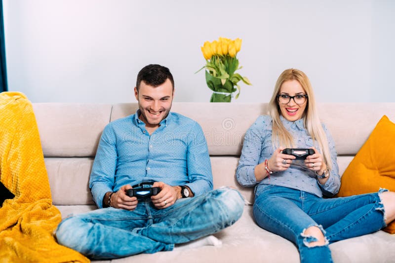 Dobiera się bawić się cyfrowe wideo gry z joysticka kontrolerem podczas gdy siedzący na kanapie lub leżance obraz stock Dobiera się bawić się cyfrowe wideo gry z joysticka kontrolerem podczas gdy siedzący na kanapie lub leżance obraz stock